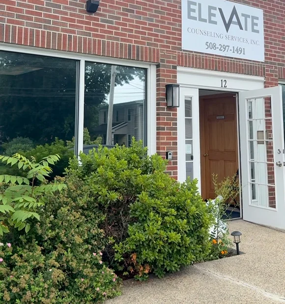 Exterior of Elevate Counseling Services with a large tinted front window and a brick facade.