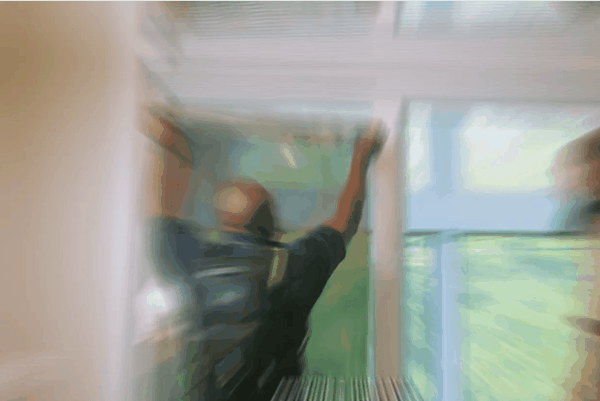 A blurred action shot shows a professional installer applying window film to a large residential window, emphasizing the speed and precision of the tinting process. Bright natural light filters through the surrounding untinted panes.