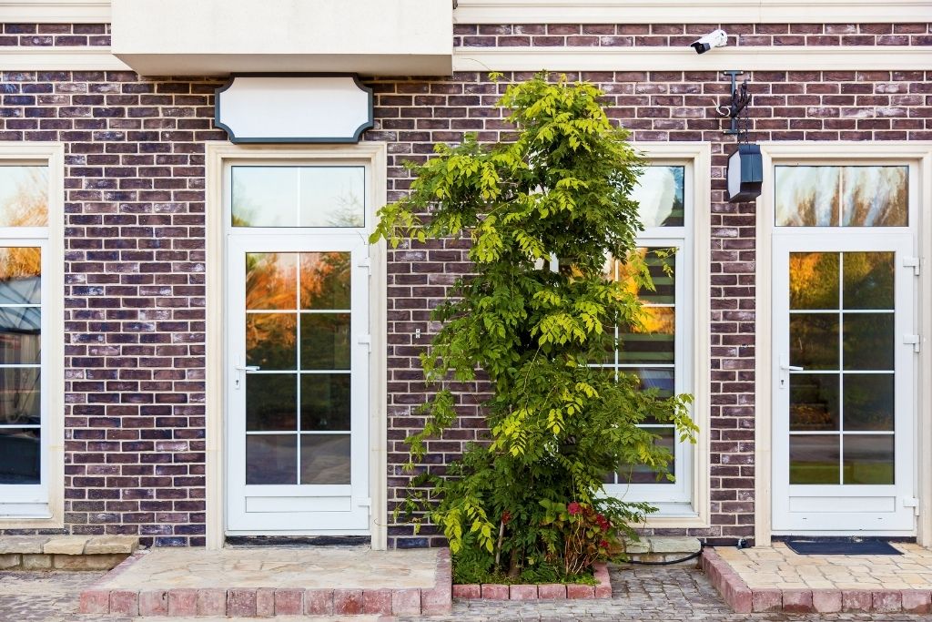 Glass entry doors and windows on a brick commercial building, showing how storefront glazing can benefit from privacy and solar-control window film.