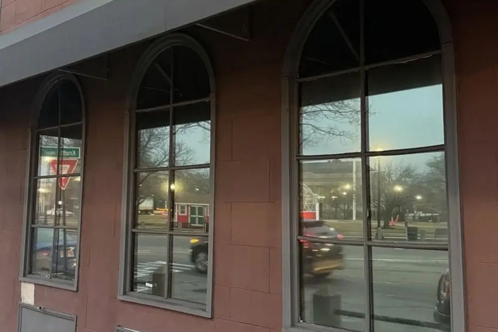 Arched commercial windows with reflective tint on a street-facing building, helping reduce glare and improve daytime privacy.